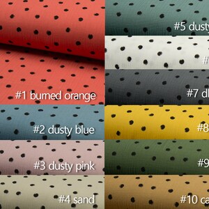 Puede incluir: Diez muestras de tela con lunares negros sobre fondos de diferentes colores. Los colores son: naranja quemado, azul polvoriento, rosa polvoriento, arena, menta polvorienta, crudo, gris oscuro, curry, ej&eacute;rcito y caramelo.