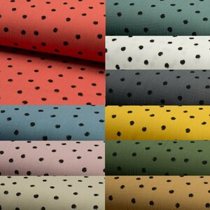 Puede incluir: Una colecci&oacute;n de diez muestras de tela con un patr&oacute;n de lunares negros sobre fondos de colores diferentes. Los colores incluyen coral, azul verdoso, blanco, gris, amarillo, verde, rosa, beige y mostaza.