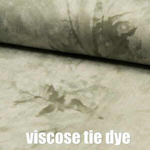 Könnte beinhalten: Ein Nahaufnahme eines hellgrünen Stoffes mit einem Batik-Muster. Der Stoff hat eine weiche, fließende Textur und einen dezenten Glanz. Der Stoff heißt "Viskose Batik".