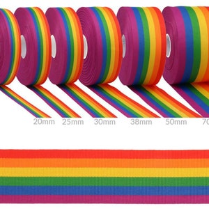 Op de afbeelding: Zes rollen regenboog lint in verschillende breedtes, van 20 mm tot 70 mm. Het lint is een klassiek regenboogpatroon met rode, oranje, gele, groene, blauwe, indigo en violette strepen.