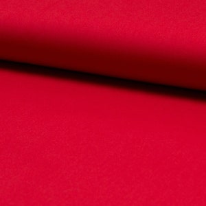 以下が含まれることがあります： 無地の赤い布のクローズアップ。布は滑らかで均一な質感です。