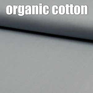 以下が含まれることがあります： 薄いグレーのオーガニックコットン生地のクローズアップ。生地は滑らかで、微妙な質感があります。