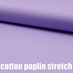 May include: A close-up of a soft, light purple fabric with a smooth texture. The fabric is labeled "cotton poplin stretch".