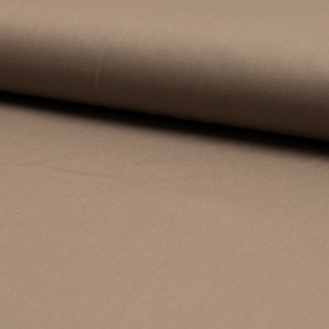 May include: A close-up of a smooth, light brown fabric. The fabric has a subtle sheen and a slightly textured surface.