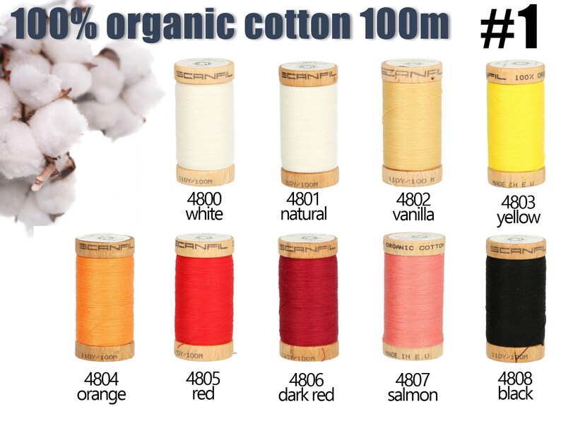 K&ouml;nnte beinhalten: Zehn Holzspulen mit 100% Bio-Baumwollgarn, jede enth&auml;lt 100m Garn. Die Farben umfassen Wei&szlig;, Natur, Vanille, Gelb, Orange, Rot, Dunkelrot, Lachs und Schwarz. Jede Spule ist mit einer Nummer und einem Farbnamen beschriftet.
