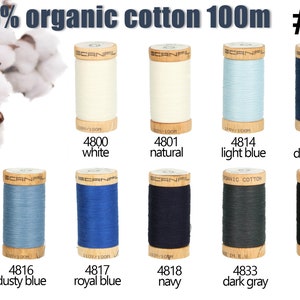 K&ouml;nnte beinhalten: Zehn Garnrollen aus 100% Bio-Baumwolle von Scanfil, jeweils 100m lang, beschriftet mit #3. Die Farben umfassen Wei&szlig;, Natur, Hellblau, Dunkelblau, Staubblau, K&ouml;nigsblau, Marine, Dunkelgrau und Schwarz, angeordnet in zwei Reihen.