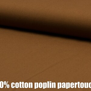 May include: Close-up of a brown 100% cotton poplin fabric with a paper-like texture.
