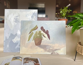 Puede incluir: Dos pinturas sobre lienzo, una con fondo azul claro y la otra con fondo beige claro. La pintura de la derecha presenta una planta verde con hojas rojas en una maceta marrón.