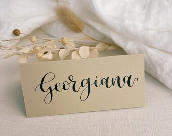 Handgeschreven plaatskaarten voor bruiloften: beige kalligrafie naamkaartjes