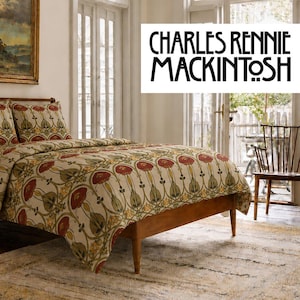 May include: A bed featuring a duvet cover and two pillows with a repeating floral pattern in shades of red, green, and gold on a cream background. The text CHARLES RENNIE MACKINTOSH is displayed in a black, stylized font in the upper right corner.