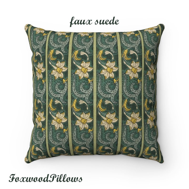 May include: A green and yellow floral patterned cushion with the text "faux suede" printed on the top. The cushion is made of a soft, faux suede fabric.