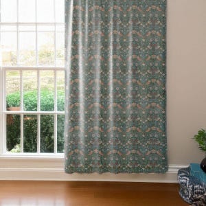 Pu&ograve; includere: Una tenda verde acqua con un motivo ripetuto di uccelli, fiori e fogliame. Il design presenta sfumature di verde acqua, marrone e bianco. La tenda &egrave; appesa davanti a una finestra.