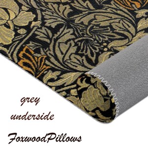 Puede incluir: Una alfombra con estampado negro y dorado con una parte inferior gris. La alfombra est&aacute; enrollada y la parte inferior es visible. El texto "Foxwood Pillows" es visible en la esquina inferior derecha.