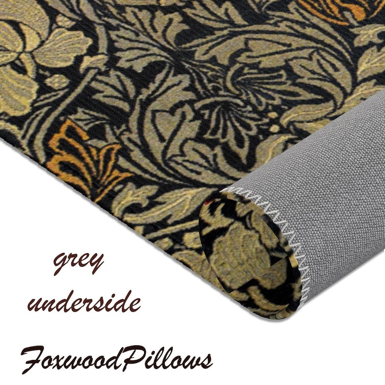 Puede incluir: Una alfombra con estampado negro y dorado con una parte inferior gris. La alfombra est&aacute; enrollada y la parte inferior es visible. El texto "Foxwood Pillows" es visible en la esquina inferior derecha.