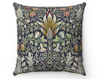 Pode incluir: Uma almofada decorativa com fundo azul escuro e um padrão floral em tons de verde, marrom, vermelho e branco. O padrão apresenta flores e folhas estilizadas.