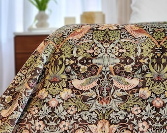 May include: A brown and green patterned fabric with a floral and bird design. The fabric features a repeating pattern of stylized birds, flowers, and leaves.