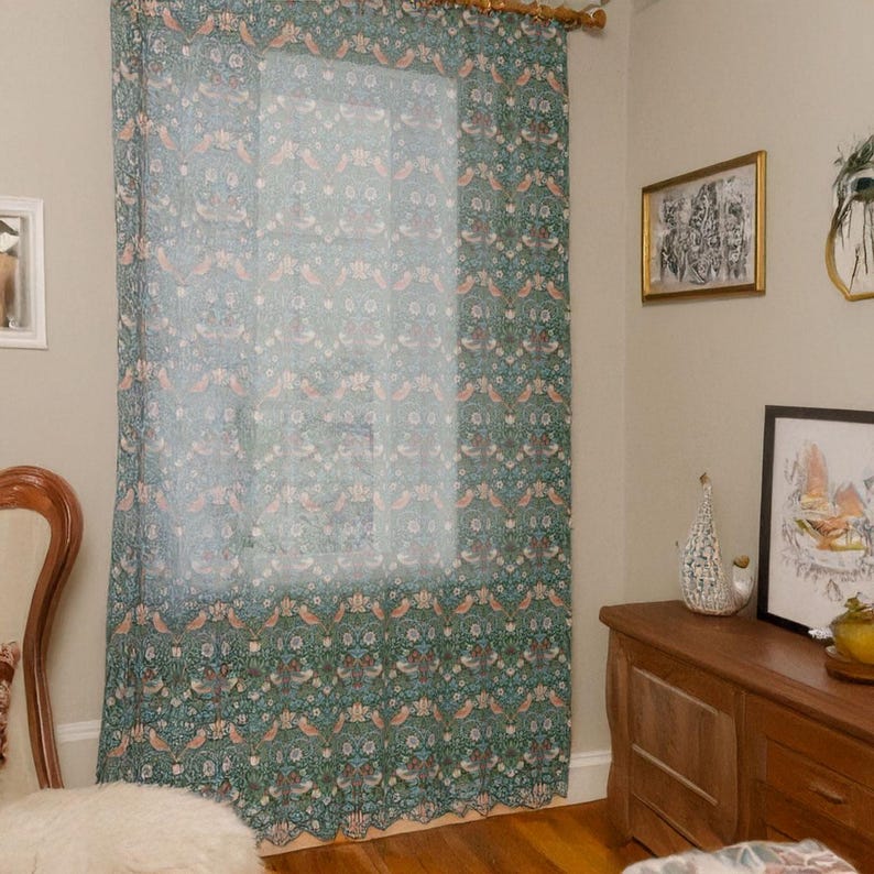 Pu&ograve; includere: Una tenda trasparente con un motivo ripetuto di uccelli ed elementi floreali nei toni del verde acqua, pesca e bianco. La tenda &egrave; appesa davanti a una finestra, aggiungendo un tocco decorativo alla stanza.
