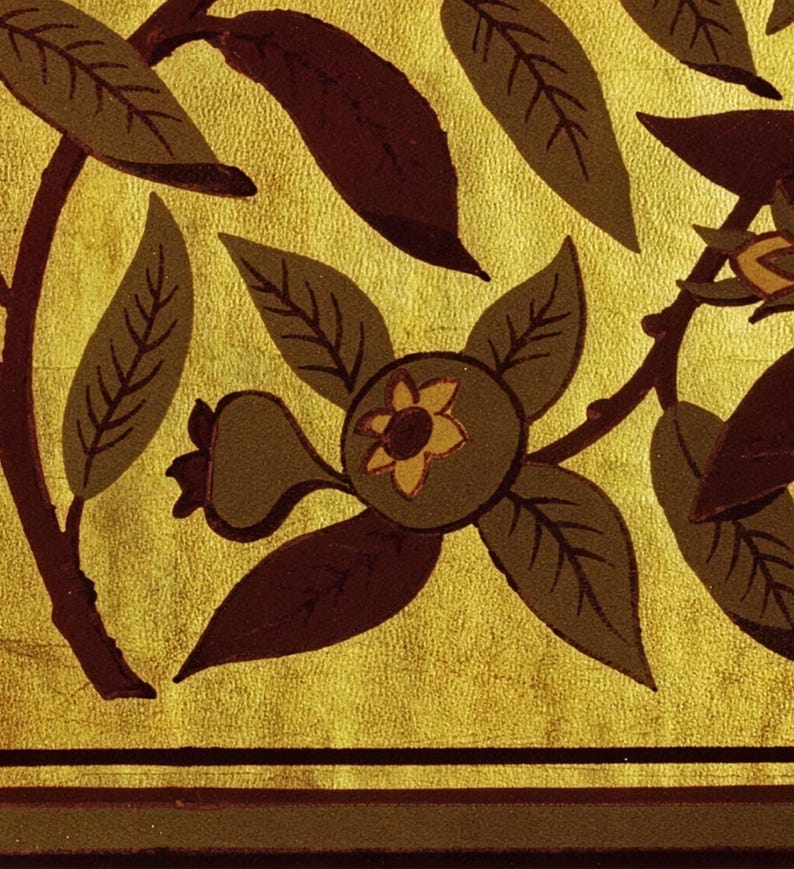 Pu&ograve; includere: Primo piano di un motivo floreale decorativo con foglie e frutti stilizzati nei toni del marrone e verde oliva su sfondo dorato. Il design include un motivo ripetuto di foglie e fiori.