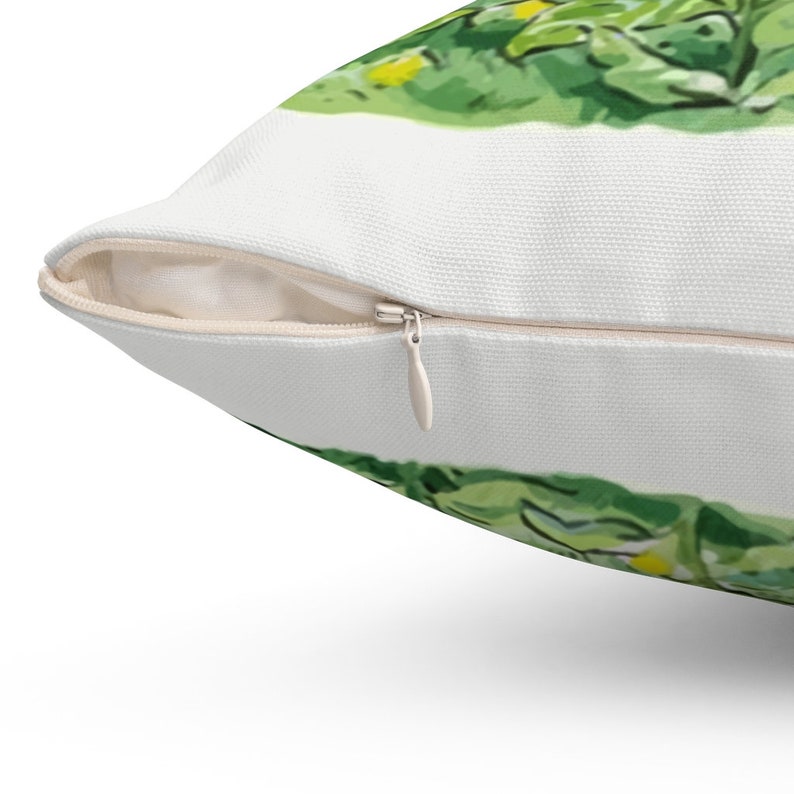 May include: A white pillow with a zipper closure. The pillow has a green and yellow floral pattern on one side.