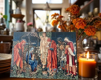 May include: A rectangular art print depicting a religious scene with figures in robes. The print features rich colors, including reds, blues, and greens. A lit orange candle sits in a glass holder to the right of the print. Orange flowers are in a vase behind the print.