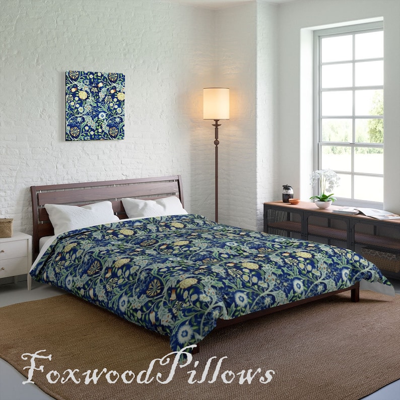 Puede incluir: Una funda n&oacute;rdica con estampado floral azul y verde con una almohada a juego en una cama con cabecero de madera. La cama est&aacute; en un dormitorio con una pared de ladrillo blanco, una l&aacute;mpara y una ventana.