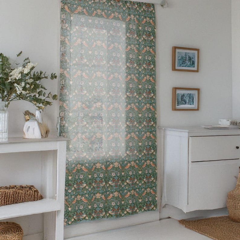 Pu&ograve; includere: Una tenda trasparente con un motivo ripetuto di uccelli, fiori e foglie nei toni del verde, arancione e marrone. La tenda &egrave; appesa davanti a una finestra, con un com&ograve; bianco e quadri incorniciati sullo sfondo.