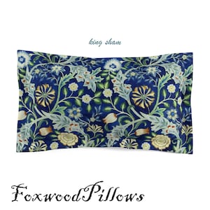 Puede incluir: Una funda de almohada tama&ntilde;o king con fondo azul y un patr&oacute;n floral en tonos verdes, blancos y amarillos. El texto "king sham" est&aacute; escrito en azul sobre la almohada.