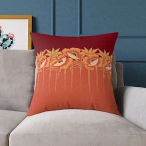 May include: A red and orange throw pillow with a floral pattern of orange flowers with yellow centres. The flowers are arranged in a row along the bottom of the pillow.