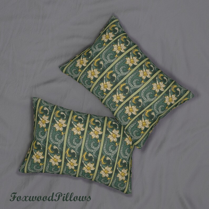 May include: Two green and yellow patterned throw pillows with a floral design. The pillows are arranged on a grey surface.