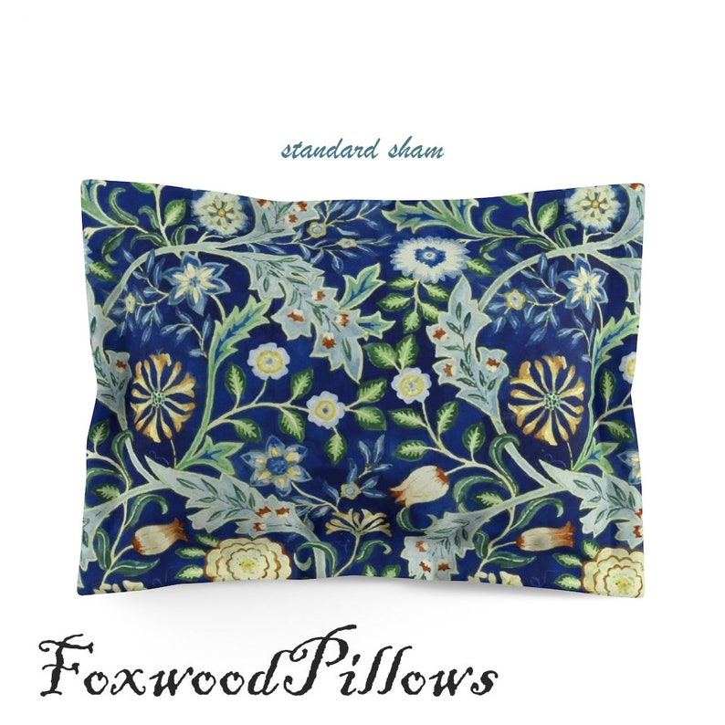 Puede incluir: Una funda de almohada est&aacute;ndar azul con un patr&oacute;n floral. La funda de almohada presenta un dise&ntilde;o repetitivo de flores blancas, amarillas y verdes sobre un fondo azul oscuro. El texto "standard sham" est&aacute; escrito en blanco sobre la funda de almohada.