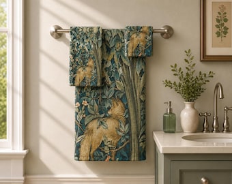 May include: A set of two rectangular towels featuring a detailed tapestry-style print of golden-brown foxes amidst dark teal foliage, green leaves, and small flowers. The towels are draped over a horizontal metal bar mounted on a wall.