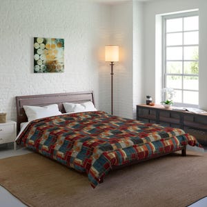 May include: A bed featuring a comforter with a geometric pattern in shades of red, blue, and tan. The bed has a dark brown wooden headboard and two white pillows. The room includes a floor lamp, a white nightstand, and a wooden console table.