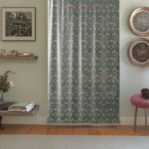 Pu&ograve; includere: Tenda a fantasia con un motivo ripetuto di uccelli, fiori e foglie nei toni del verde acqua, pesca e crema. La tenda &egrave; appesa davanti a un muro, con un pavimento in legno e uno sgabello rosa visibili.