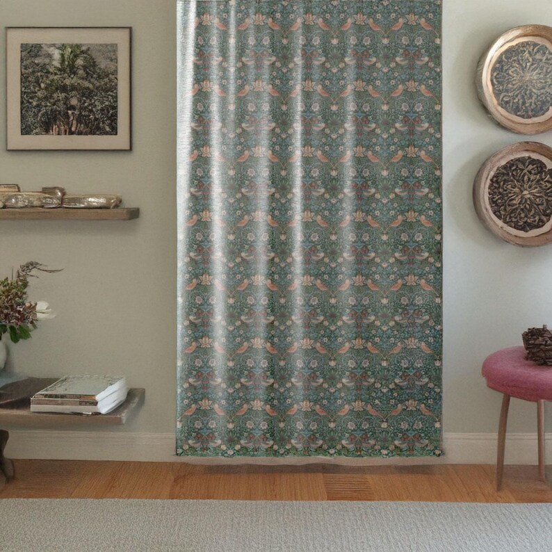 Pu&ograve; includere: Tenda a fantasia con un motivo ripetuto di uccelli, fiori e foglie nei toni del verde acqua, pesca e crema. La tenda &egrave; appesa davanti a un muro, con un pavimento in legno e uno sgabello rosa visibili.