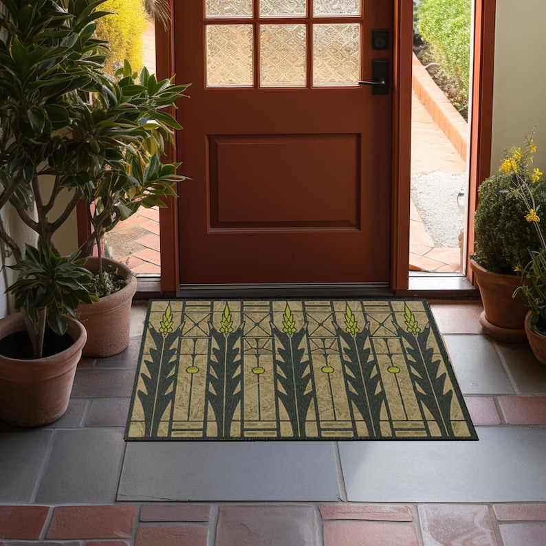 May include: A doormat with a geometric design featuring green and yellow wheat stalks on a beige background. The doormat is placed in front of a wooden door with glass panels.