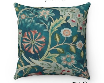 Pode incluir: Uma almofada azul turquesa com um padrão floral em tons de rosa, verde e branco. A almofada é feita de camurça sintética e tem o texto "Foxwood Pillows" e "Side B" impresso na parte inferior.
