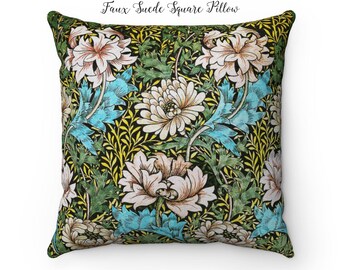Pode incluir: Uma almofada quadrada com um padrão floral. A almofada é feita de camurça sintética e apresenta um fundo preto com flores brancas, rosas, azuis e verdes. O texto "Faux Suede Square Pillow" está escrito acima da almofada.