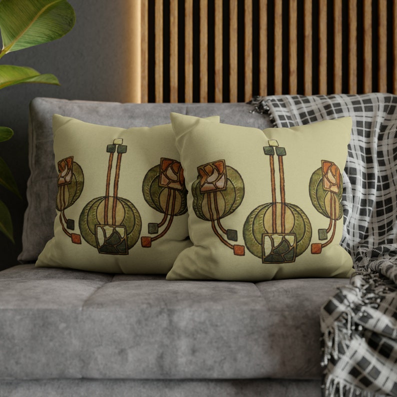 May include: Two decorative throw pillows with a beige background and a repeating pattern of stylized green, brown, and orange flowers. The pillows are on a gray couch.