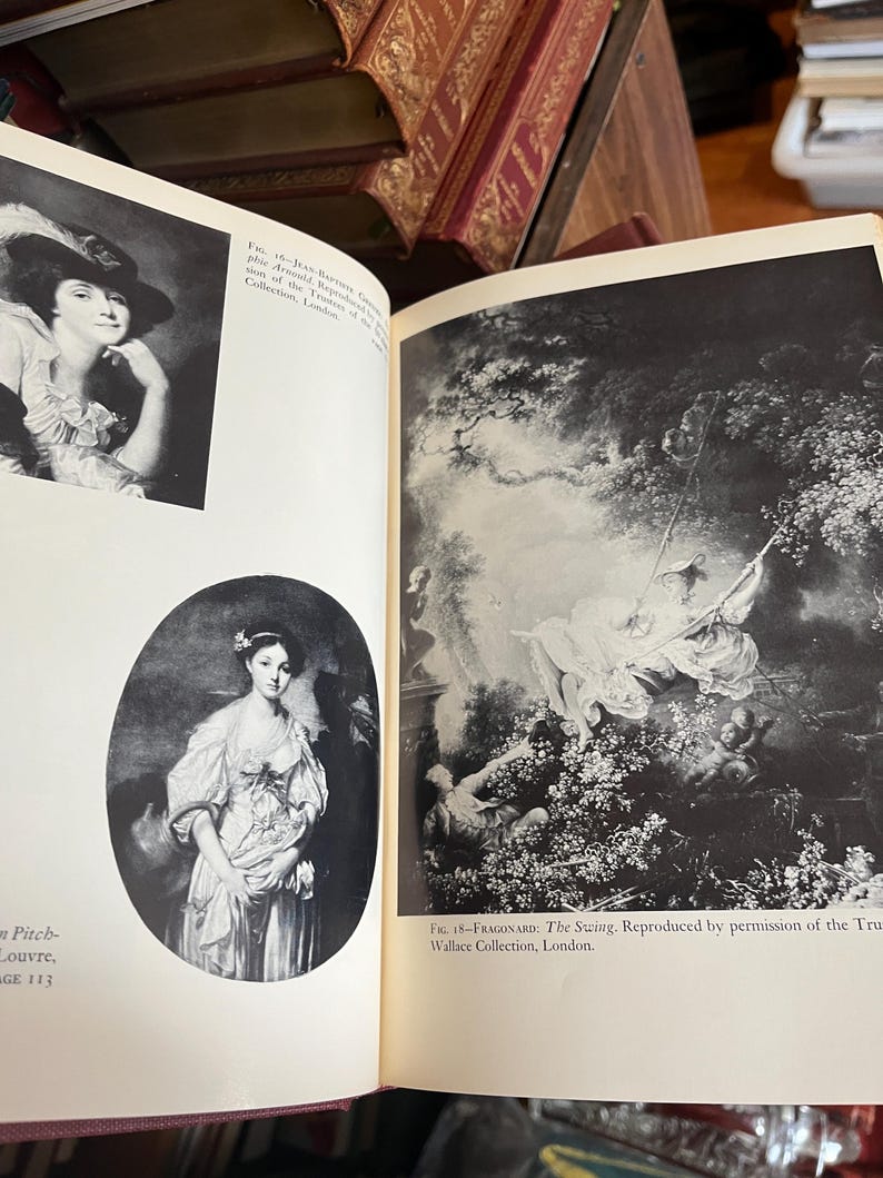 May include: Open book with black and white reproductions of classic paintings. One image is a portrait of a woman in a hat, the other depicts a scene of figures on a swing. Text includes "Louvre" and "Wallace Collection, London."