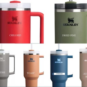 May include: Six Stanley brand insulated travel mugs with lids and handles. The mugs are in various colours: chili red, dried pine, stone, toast, stargaze, and almond rose.