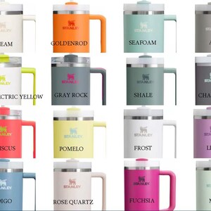 May include: Twelve different colour variations of a stainless steel travel mug with a handle. The mug has a lid with a drinking spout and a clear plastic lid. The mug is labelled "Stanley".