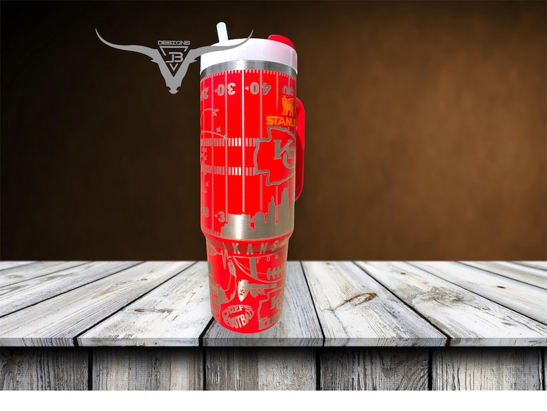 Pu&ograve; includere: Un thermos da viaggio in acciaio inossidabile rosso con un coperchio bianco e un manico nero. Il thermos &egrave; decorato con un design di campo da football e le parole "Kansas City Chiefs" e "Chiefs Football".