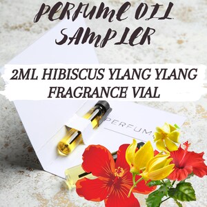 May include: A 2 ml glass vial of Hibiscus Ylang Ylang fragrance oil. The vial is in a white cardboard box with the words "PERFUME OIL SAMPLER" printed on the top. The box is surrounded by red hibiscus and yellow ylang ylang flowers.