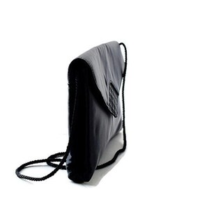 Puede incluir: Bolso de mano negro con cierre de solapa y detalle tejido. El bolso tiene una larga correa de cuerda negra. El bolso est&aacute; hecho de un material liso y brillante.