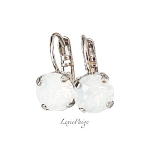 May include: A pair of silver hoop earrings with a white opal stone in the center of each hoop.