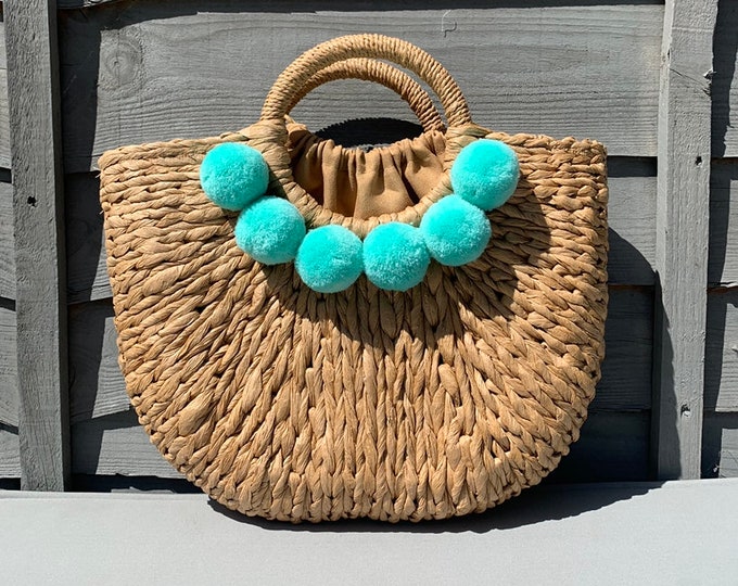 Straw bag with pom poms