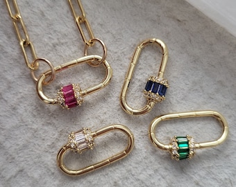 May include: Four gold-toned metal clasps with different colored gemstones. The clasps are oval-shaped and have a small, round gemstone in the center. The gemstones are pink, blue, green, and clear.