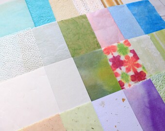 May include: A collection of different textured and patterned papers in various colors, including white, blue, green, pink, and purple. The papers are arranged in a grid pattern.