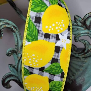 Puede incluir: Cinta decorativa con un patr&oacute;n repetido de limones amarillos brillantes, hojas verdes y flores blancas sobre un fondo a cuadros blanco y negro. La cinta tiene un borde cosido amarillo. Ideal para manualidades y decoraci&oacute;n.