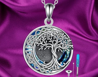 May include: A silver necklace with a round pendant featuring a detailed tree of life design with a blue and green abalone shell inlay. The pendant is surrounded by a Celtic knot border. The necklace comes with a funnel and a small screwdriver.